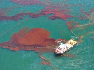 A boat skims oil from the water in the Gulf of Mexico