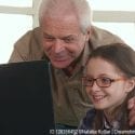 Grandpa and granddaughter on computer researching their family history