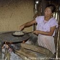 A woman in Guatemala using an indoor stove to prepare food.