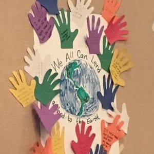 Handprints with environmental goals written on them