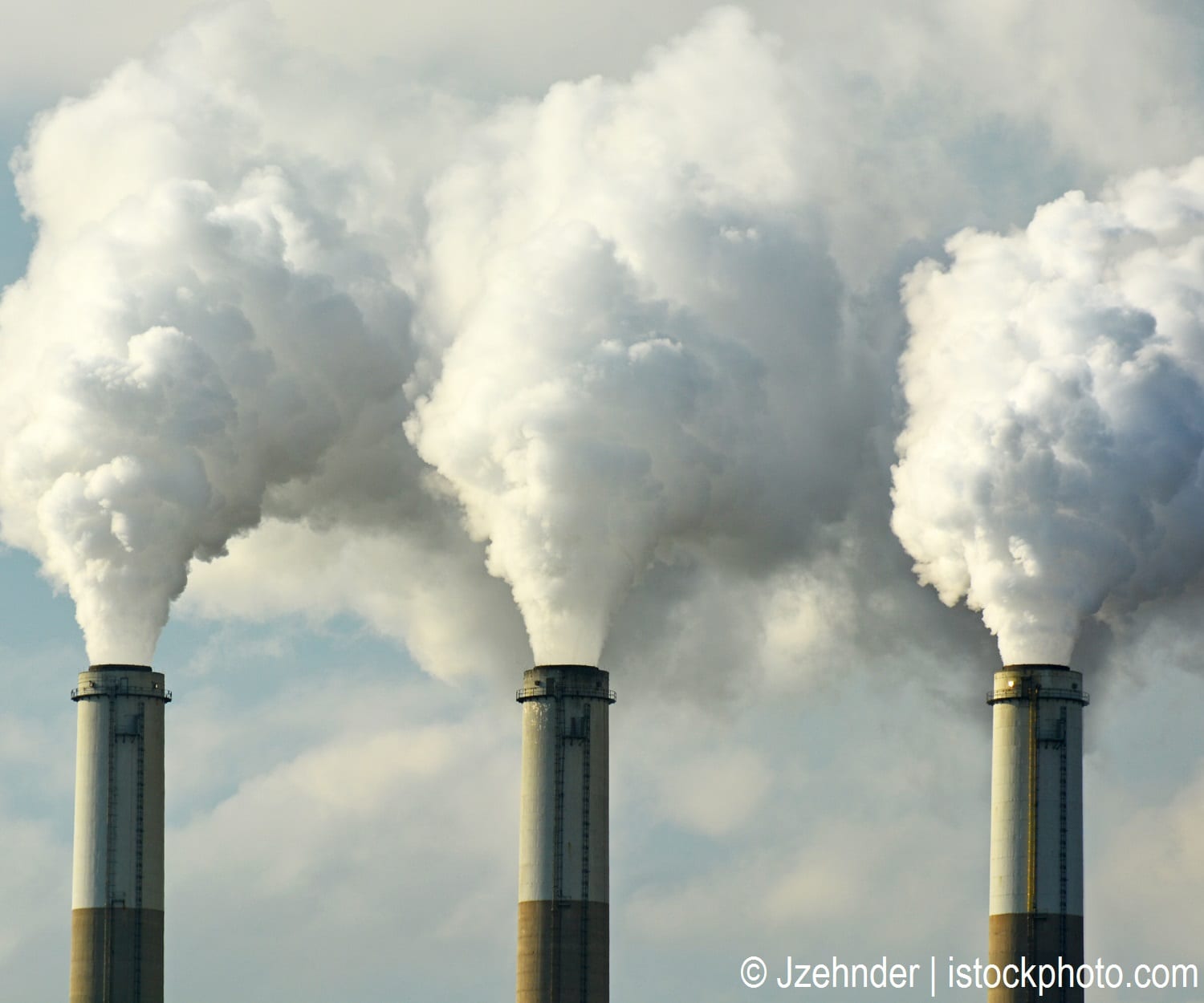 Smoke stacks at a power plant emitting smoke, a major source of air pollution.