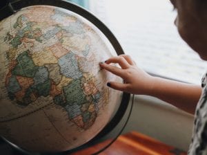 Young child with her finger pointing on a globe