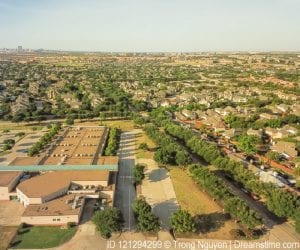 Aerial view of Irving, Texas shows green space among school, homes and roads.