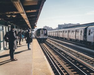 NYC subway approaches platform with passengers waiting