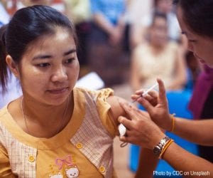 Woman receiving vaccine from nurse