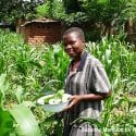 Teenage girl in Malawi holding pumpkin leaves to make lunch