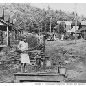 Photo of US History: Pumping water by hand in 1942 from the sole water supply in this section of Wilder, TN