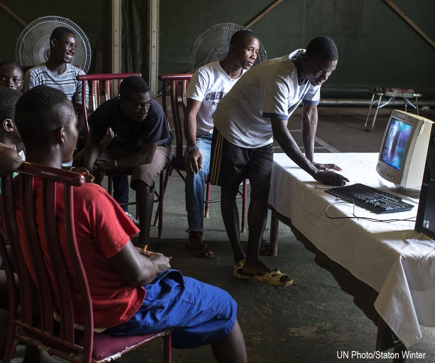 Electricity allows young Liberian men work at a computer station at Camp Clara during a five-day computer course