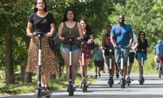 People ride e-scooters, a new means of transportation in the United States today