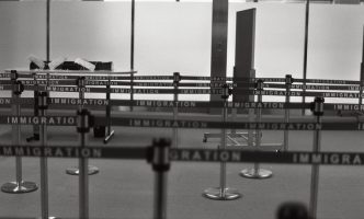 Empty airport immigration waiting area with roped off lines for crowd control