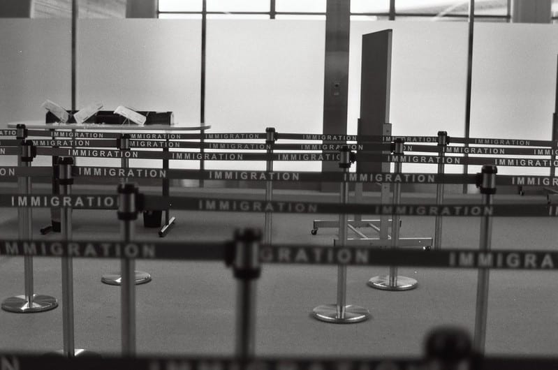 Empty airport immigration waiting area with roped off lines for crowd control