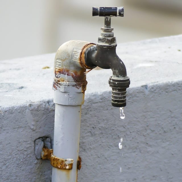 Water dripping from white and brown faucet