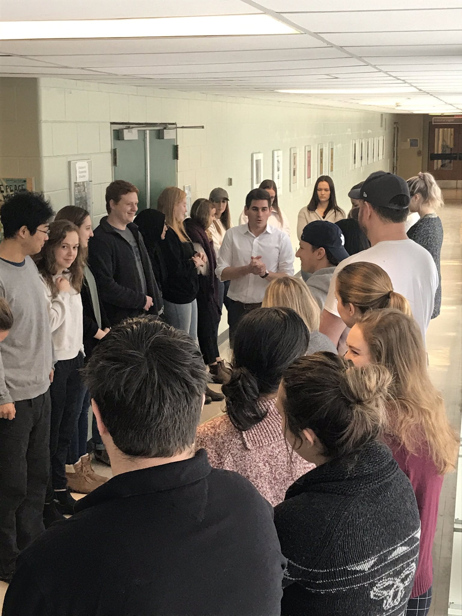 Students at King's University stand in a circle while a facilitator talks them through a demonstration of the Population Circle activity.