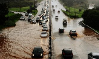 Flooding causes traffic jam as cars move along severely flooded roads