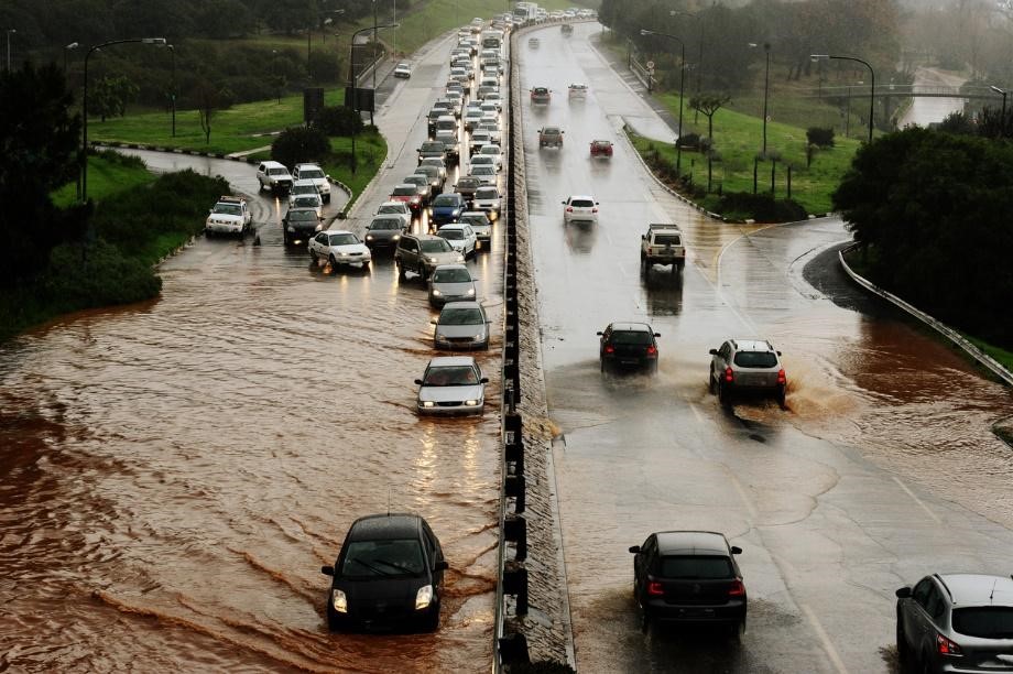 Flooding causes traffic jam as cars move along severely flooded roads