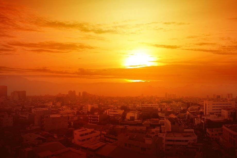 Heatwave creates orange haze over city while sun glows in the background