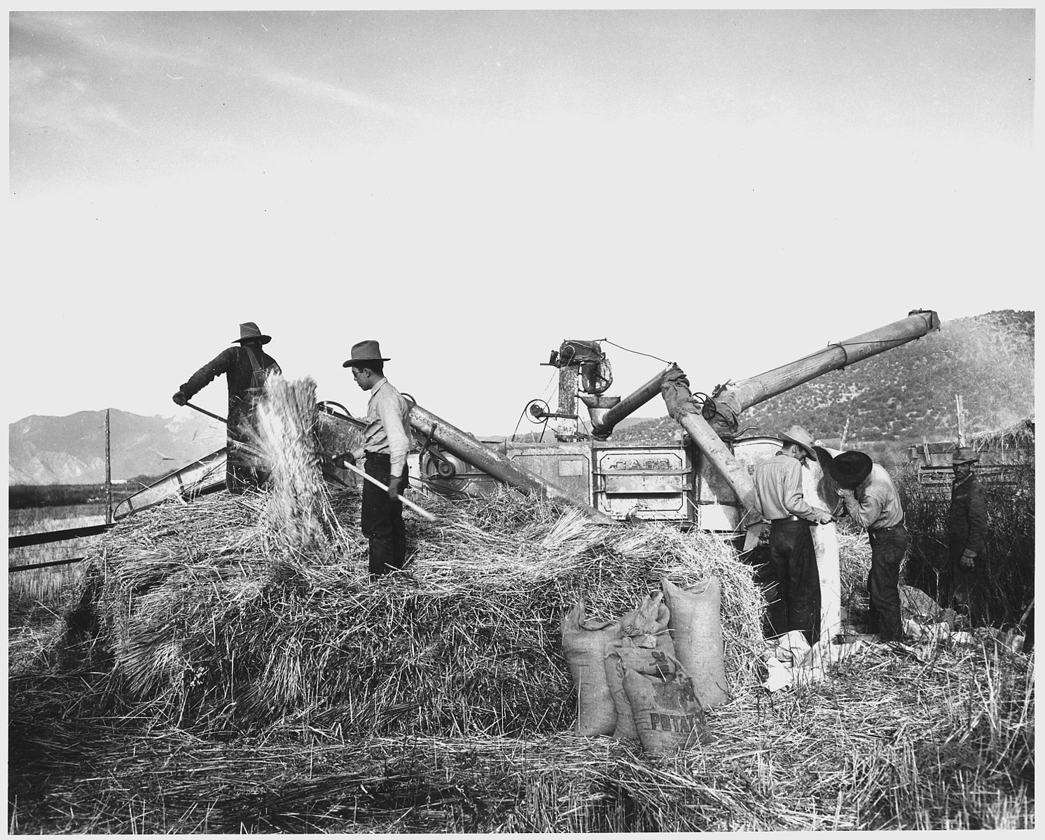 Farmers using a threshing machine.