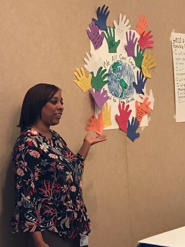 Trainer shows off ‘helping hands’ from the lesson Lend a Hand to the Earth at a state teaching conference.