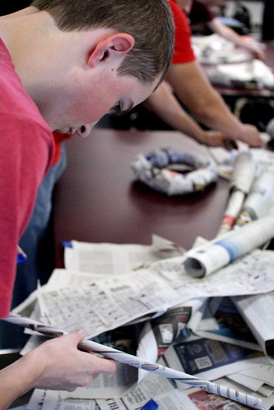 Students build a newspaper tower in an Engineering class