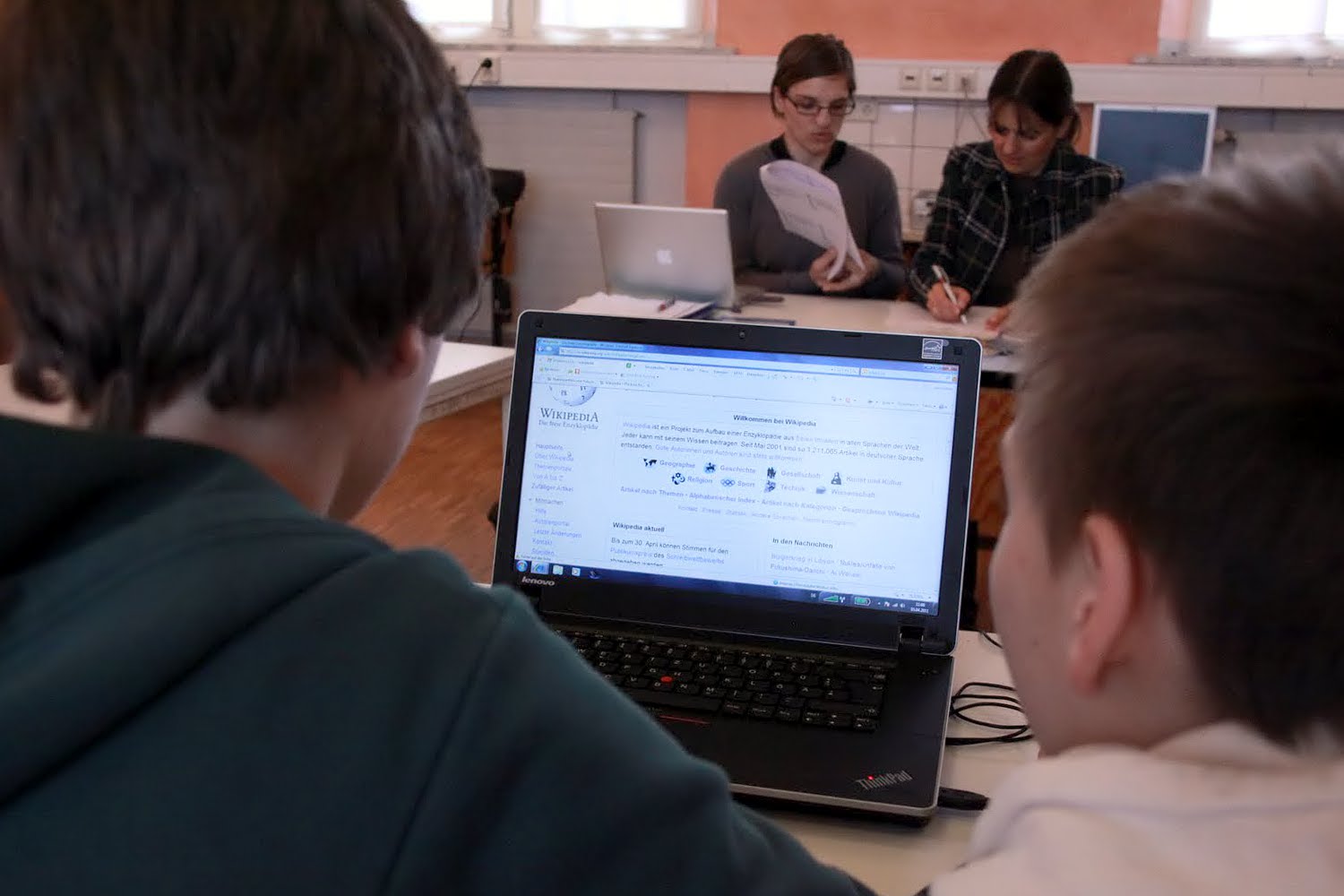 Two students doing research on a laptop computer