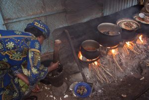 A woman cooks over indoor wood fires in Burkina Faso.