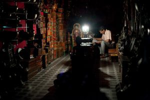A battery-powered lamp is the only source of light in a Nepalese shop during a load shedding outage.