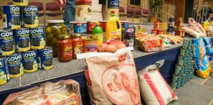 Donated dry goods including beans, rice, and soups stretch across a counter after a USDA summer food drive.