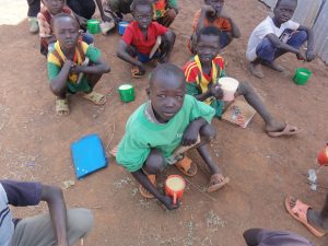 A group of six Sudanese children eat fortified porridge in a refugee camp in Ethiopia. 