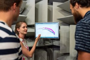 Engineer showing data on a screen to colleagues. 