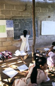 A young girl writes on a chalkboard during a geometry lesson in a rural school in Mexico.
