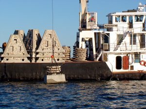 As part of coral reef restoration, artificial reefs are lowered into the ocean from a large ship off the coast of Mexico.
