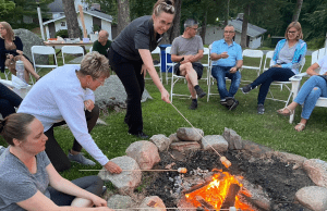 Marni Landry, PopEd's Most Valuable Trainer of 2025, roasts a marshmallow at a PopEd Leadership Institute.