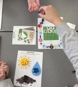 Students play Lessons from the Lorax, a PopEd activity where resources are pooled to restore a forest.