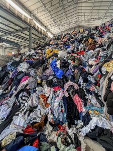 A mountain of donated clothes inside a secondhand store warehouse