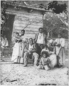 A black-and-white photo of a multi-generational family who were enslaved on a cotton plantation in South Carolina, 1862.